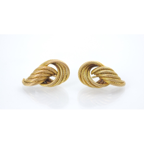 177 - A pair of yellow metal earrings, the stylised knot studs with engraved detail, with screw and butter... 