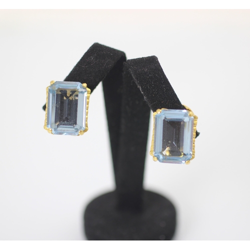 178 - A pair of blue synthetic spinel earrings, the emerald cut blue stones claw set in yellow metal with ... 