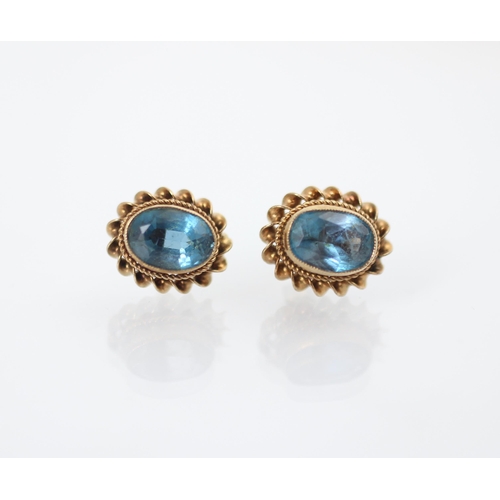 179 - A pair of 9ct yellow gold untested blue topaz earrings, the oval cut stones within gold rope twist b... 