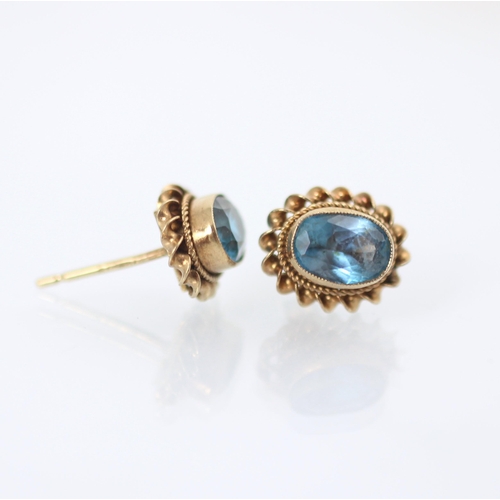 179 - A pair of 9ct yellow gold untested blue topaz earrings, the oval cut stones within gold rope twist b... 