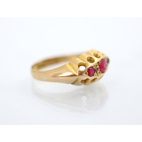 188 - An early 20th century 18ct yellow gold untested ruby ring, the three graduated red stones with a dia... 