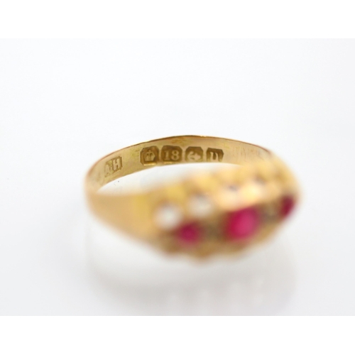 188 - An early 20th century 18ct yellow gold untested ruby ring, the three graduated red stones with a dia... 