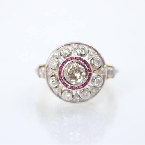 192 - An Art Deco style diamond and ruby target ring, the central round cut diamond within a surround of c... 