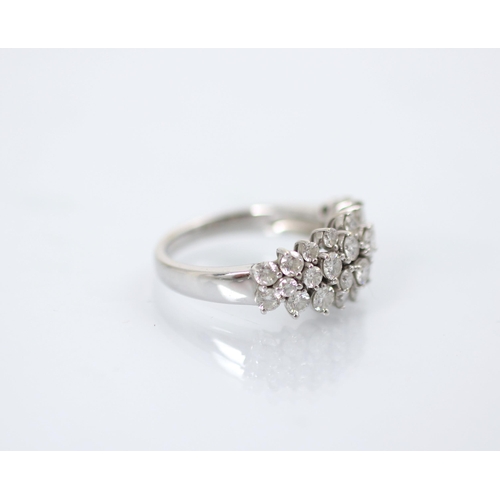 193 - A stylised diamond cluster ring, the graduated round cut diamonds set within a raised claw set mount... 