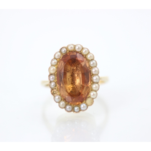 207 - A 19th century style foiled back ring, the oval cut apricot stone within a surround of twenty split ... 