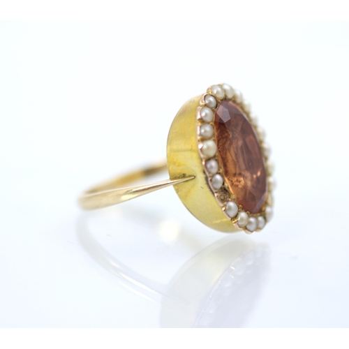 207 - A 19th century style foiled back ring, the oval cut apricot stone within a surround of twenty split ... 