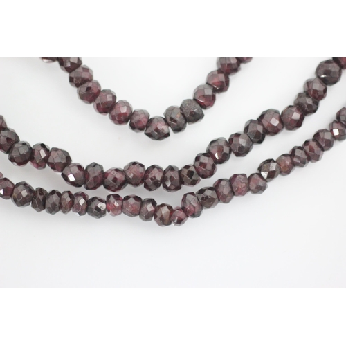 209 - A 19th century style triple strand necklace, the faceted red stones of non uniform spherical shape, ... 