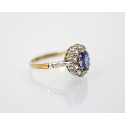 215 - An Edwardian style synthetic sapphire cluster ring, the oval cut blue stone within surround of ten w... 