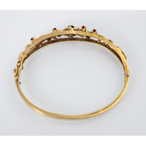 224 - A 9ct yellow gold Victorian style bangle, the openwork bangle with flowerhead and foliage detail, se... 