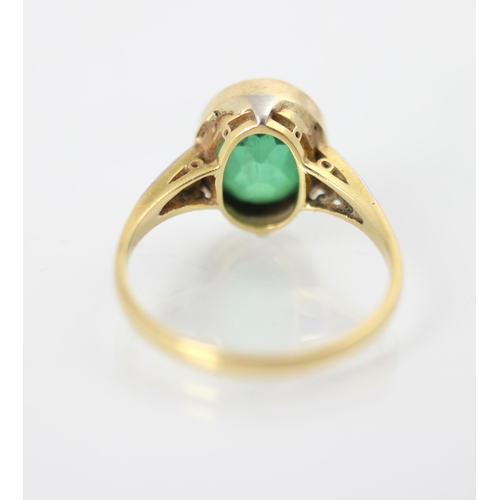 235 - An early 20th century green paste and diamond set ring, the oval cut green stone within white metal ... 