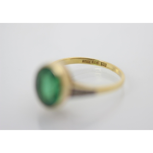 235 - An early 20th century green paste and diamond set ring, the oval cut green stone within white metal ... 