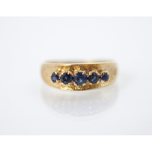 243 - A 9ct yellow gold and untested sapphire dress ring, the five graduated round cut blue stones raised ... 