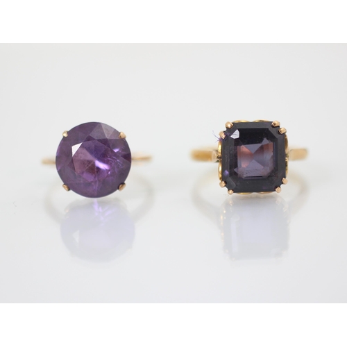 250 - An untested amethyst set dress ring, the emerald cut stone within yellow metal double claw setting e... 