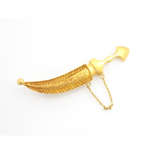 254 - A yellow metal brooch, the brooch designed as a jambiya, the dagger removeable from filigree detaile... 