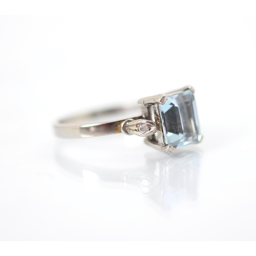 263 - An untested aquamarine and diamond ring, the central emerald cut aquamarine set with a round cut dia... 