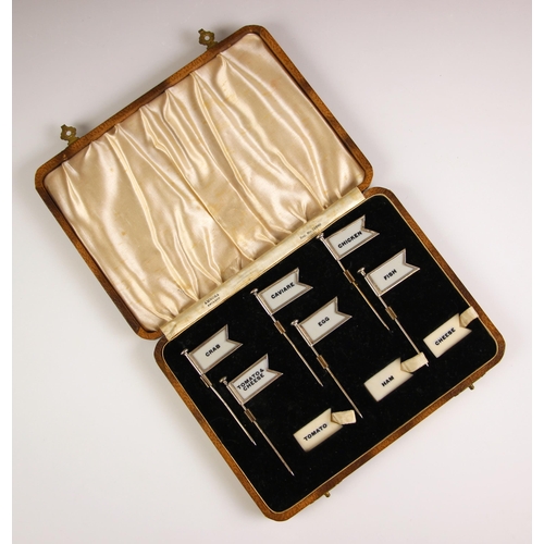 69 - A cased set of six sterling silver sandwich flags or labels by Amnora, early 20th century, the six f... 