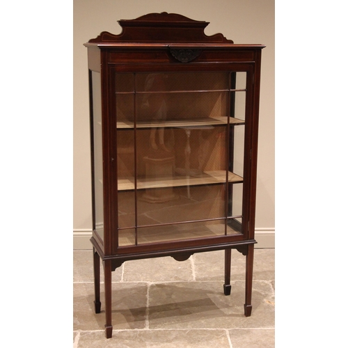 825 - An Edwardian mahogany display cabinet, with a shaped rear pediment over a breakfront top, moulded an... 