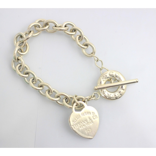 184 - A white metal bracelet, in Tiffany and Co style, the trace link chain with heart shaped pendant stam... 