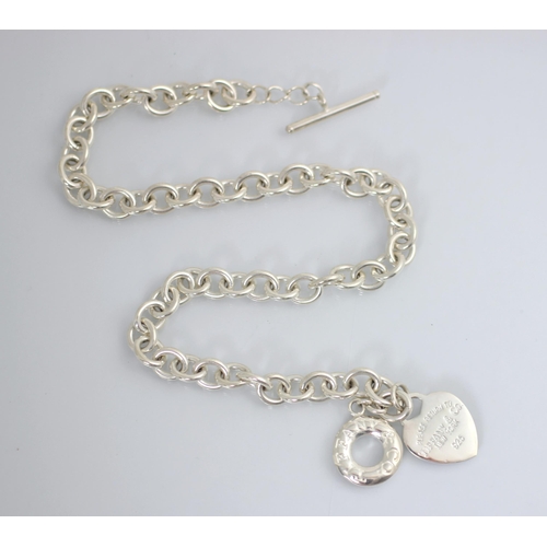 185 - A white metal necklace, in Tiffany and Co style, the trace link chain with heart shaped pendant stam... 