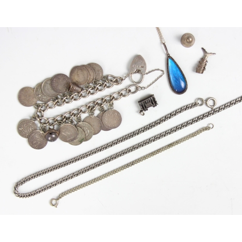 206 - A silver coloured charm bracelet, the curb link bracelet suspending various three pence charms and b... 