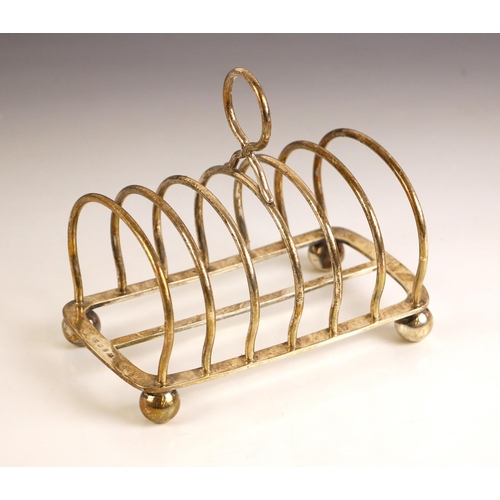 83 - A Victorian silver toast rack, Elkington and Co Ltd, Birmingham 1898, the circular thumb piece above... 