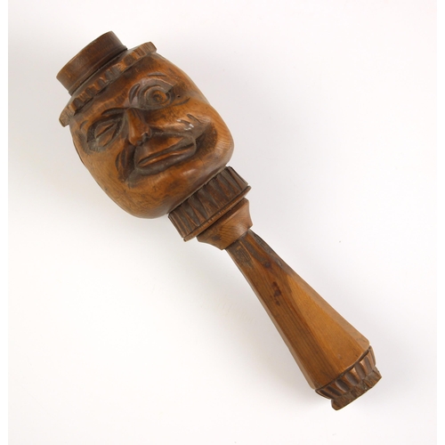 254 - A treen novelty nut cracker, late 19th/early 20th century, the front carved with a face, geometric d... 