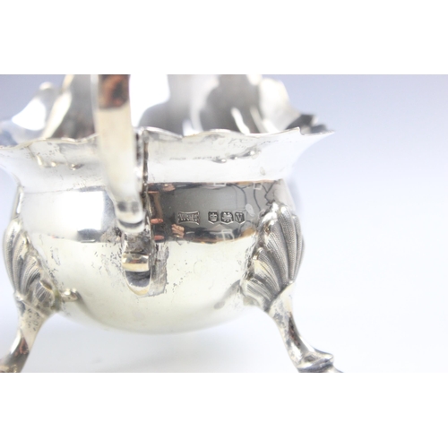 27 - A near pair of George VI silver sauce boats, Walker and Hall, Sheffield 1938-1940, the shaped rim ab... 