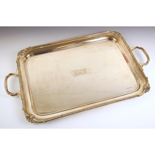 67 - A George V silver tray, L Harrison, Sheffield 1931, the shaped twin handled tray with shell shaped c... 