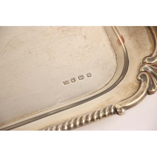 67 - A George V silver tray, L Harrison, Sheffield 1931, the shaped twin handled tray with shell shaped c... 