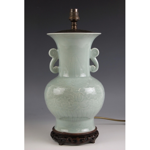 686 - A Chinese porcelain celadon lamp base, with all over scrolling leaf and vine decoration, hardwood ba... 