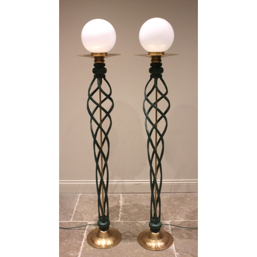 697 - A pair of contemporary wrought iron open twist floor lamps, each with a spherical opaque glass shade... 