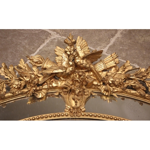 702 - A 19th century giltwood and gesso oval wall mirror, surmounted with a pair of birds, quiver of arrow... 