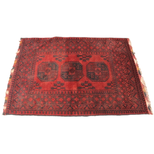 724 - A washed red Afghan double knot rug, full pile Bokhara, the three octagonal medallions upon a red gr... 