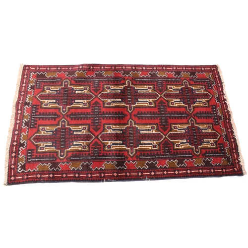 726 - A small Afghan Beluchi tribal rug, unique all over design, in red, blue and brown colourways, the ce... 