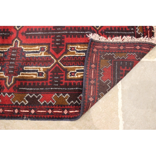 726 - A small Afghan Beluchi tribal rug, unique all over design, in red, blue and brown colourways, the ce... 