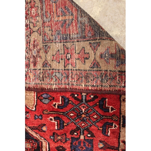 729 - A rich red ground Persian Heriz runner, bespoke medallion design, the three linked geometric medalli... 