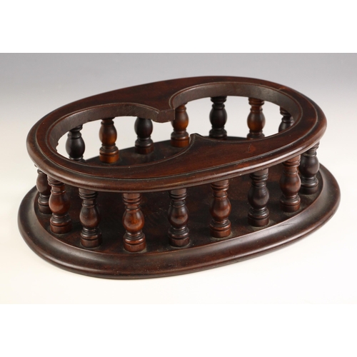 746 - A 19th century mahogany twin decanter stand, of moulded oval form, the twin bottle aperture upon a t... 