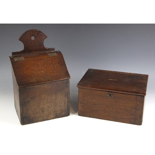 747 - An 18th century oak candle box, the shaped back over a sloping hinged cover, later pine base, 36cm H... 