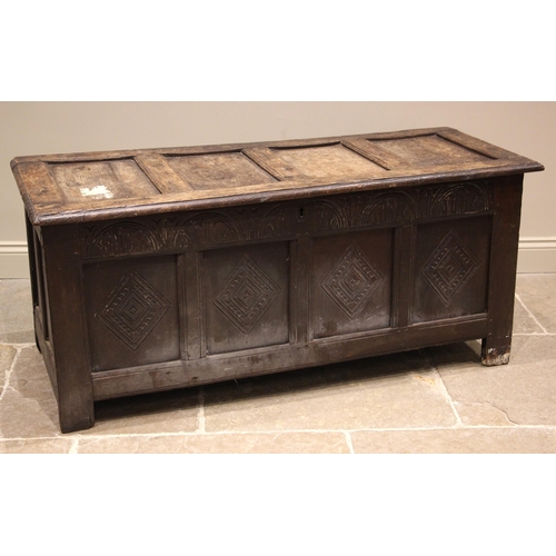 772 - A late 17th/early 18th century oak coffer, the hinged four panel top over a lunette carved frieze an... 