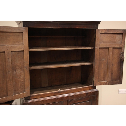 775 - An 18th century oak livery/hall cupboard, of cottage proportions, probably Welsh, the moulded cornic... 