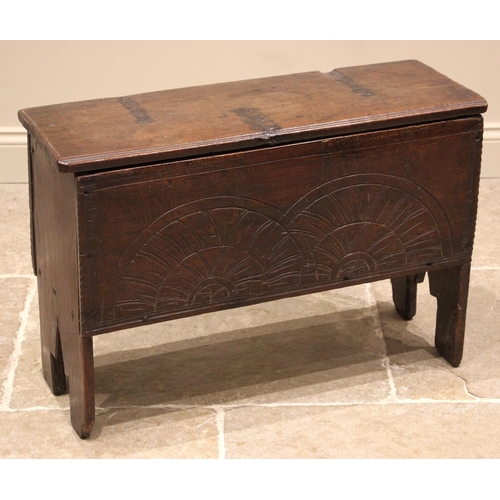 777 - A 17th century oak six plank coffer, the moulded top on later hinges over a front panel carved with ... 