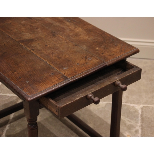 779 - An 18th century oak side table, the moulded three plank top over a frieze drawer to the side, upon t... 