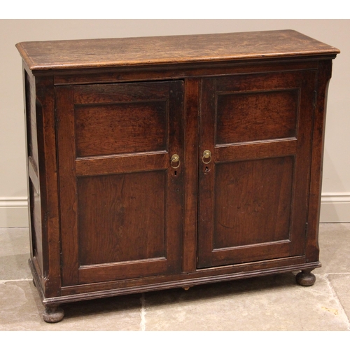 780 - An 18th century and later oak spice cupboard, the rectangular moulded top over canted corners flanki... 