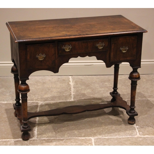 789 - A William and Mary style figured walnut low boy, 19th century, the book veneered moulded top over an... 