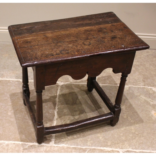 791 - A 17th century Welsh oak side table, the moulded plank top upon tapering cylindrical and block suppo... 