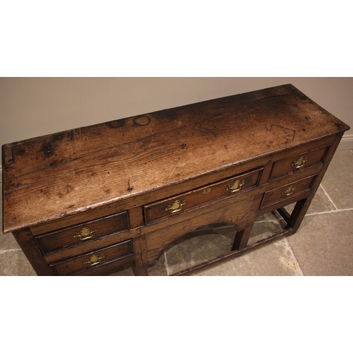 792 - An 18th century oak dresser, the open plate rack with a moulded cornice and plain frieze over three ... 