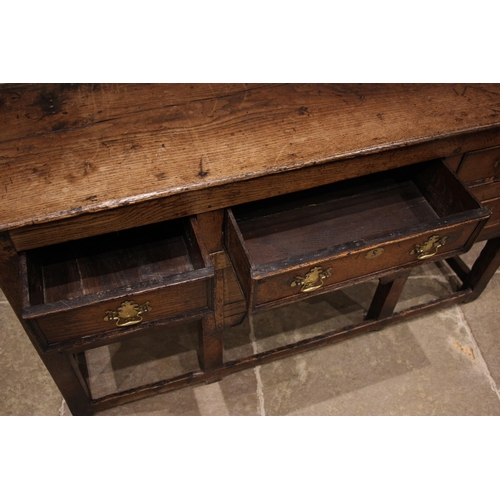 792 - An 18th century oak dresser, the open plate rack with a moulded cornice and plain frieze over three ... 