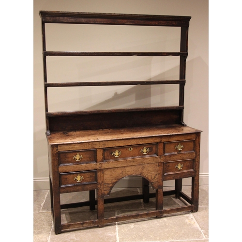 792 - An 18th century oak dresser, the open plate rack with a moulded cornice and plain frieze over three ... 