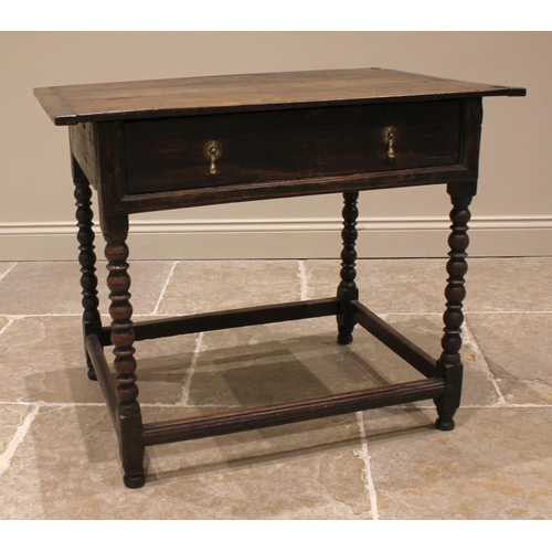 793 - An 18th century oak side table, the cleated plank top over a single oak lined frieze drawer, upon bo... 