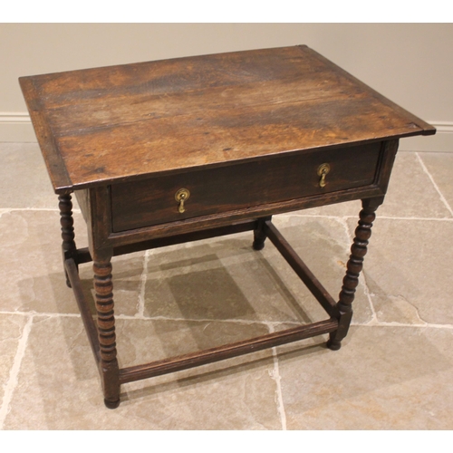 793 - An 18th century oak side table, the cleated plank top over a single oak lined frieze drawer, upon bo... 